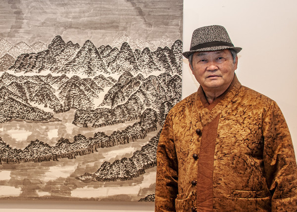 이달 15일 옥천전통문화체험관 전시실에 전시된 그의 작품 ‘부소담악의 겨울’ 옆에 서 있는 박찬훈 화가