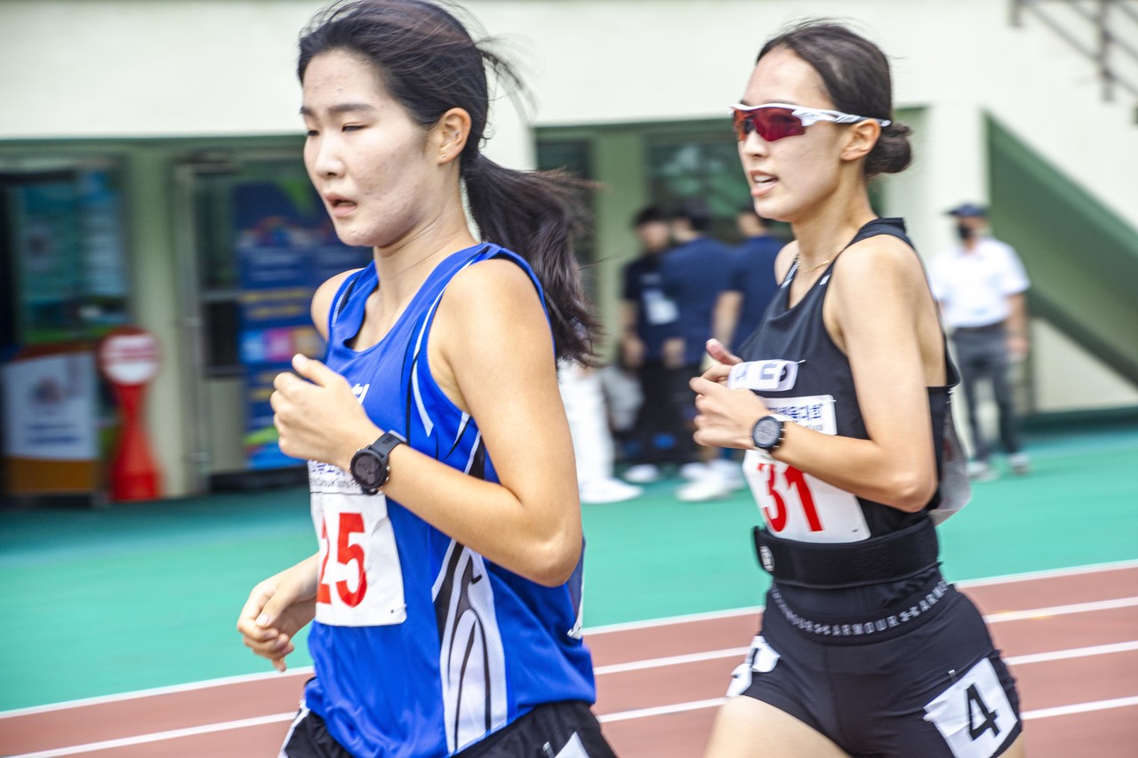 육상 여자 경기에서 두 선수가 경쟁하고 있다