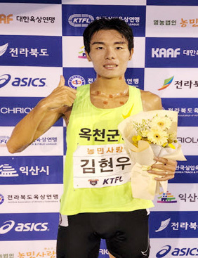 금메달을 딴 김현우 선수가 꽃다발을 들고 있다.