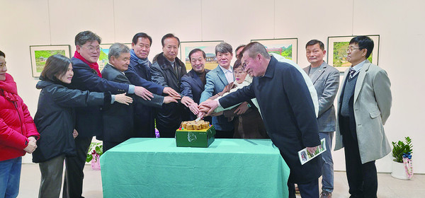 홍기엽 씨(가운데)가 사진전에 참석한 내빈들과 케이크커팅식을 진행하고 있다.